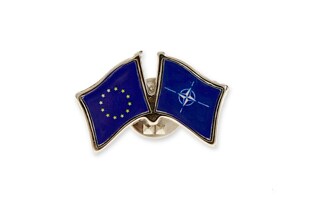 Znaczek ten przedstawia dwie przylegające do siebie flagi, które symbolizują współpracę i jedność między Unią Europejską a NATO